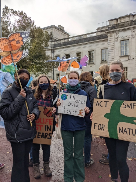4 young people at the climate strike holding placards