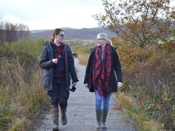 Two young women walking along a boardwalk