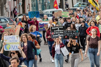 Young people walking through the streets holding climate change placards
