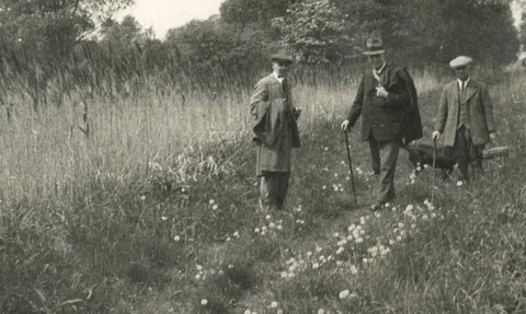 A black and white image of Rothschild walking through a field