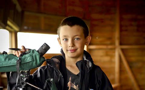 Ben in a bird hide with a telescope