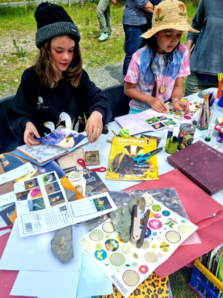 two young girls doing nature crafts