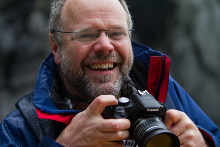 Rory Francis holding a camera and smiling
