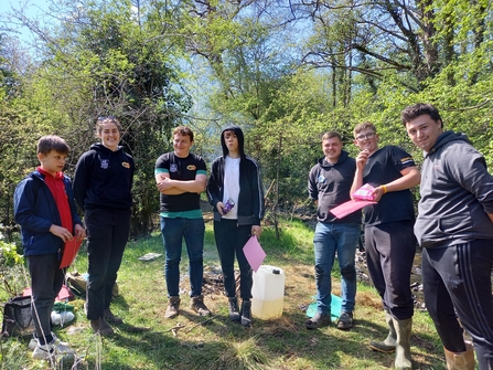 Photo of 7 young people stood outdoors in wellies