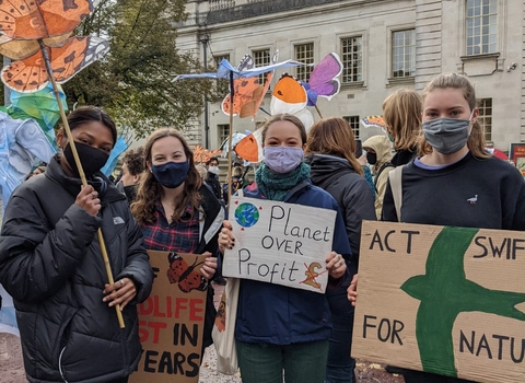 4 young people at the climate strike holding placards