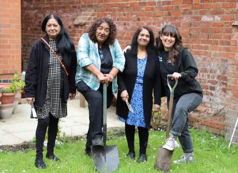 Four women with gardening tools
